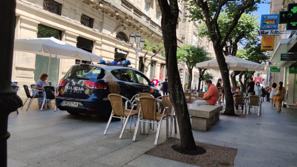 Rúa do Paseo. Terrazas y coche de la policía.