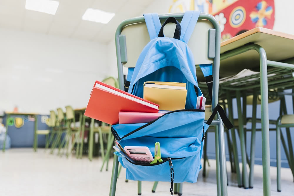 Colegio con pupitres y libros