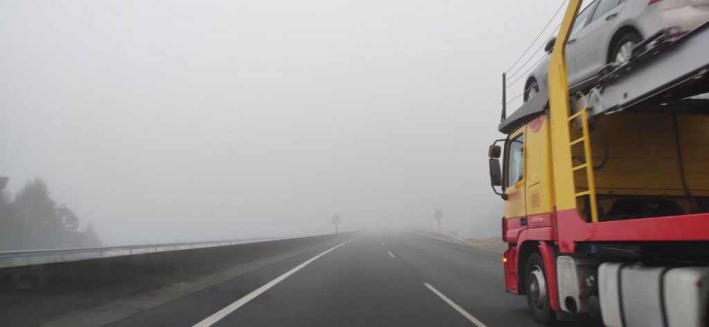 Camión por la autovía con niebla