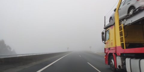 Camión por la autovía con niebla