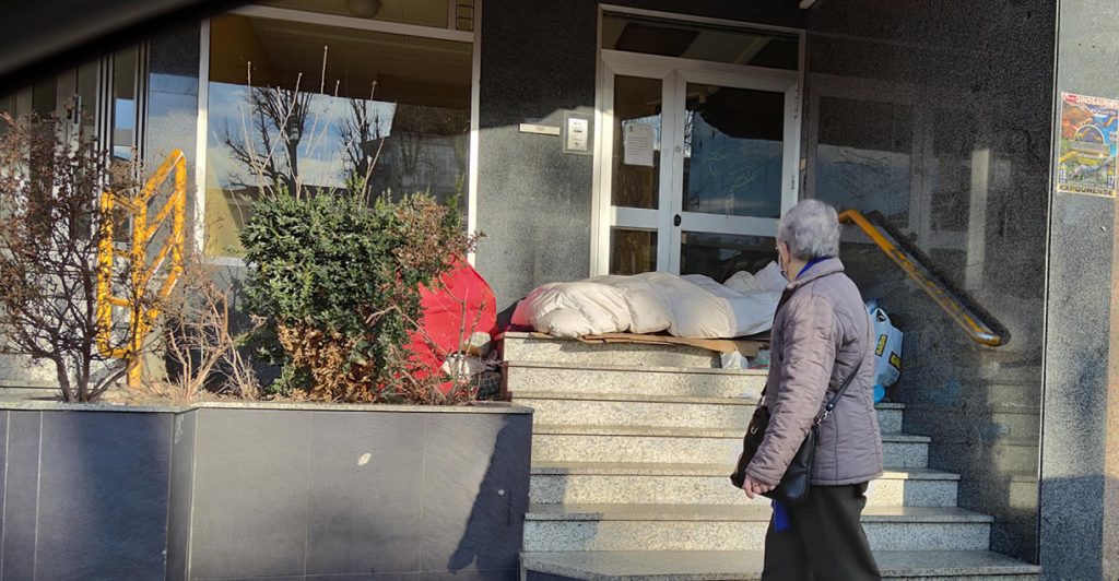 Cuando la calle es tu único refugio 2 Persona sin techo durmiendo en la calle con señora mirando